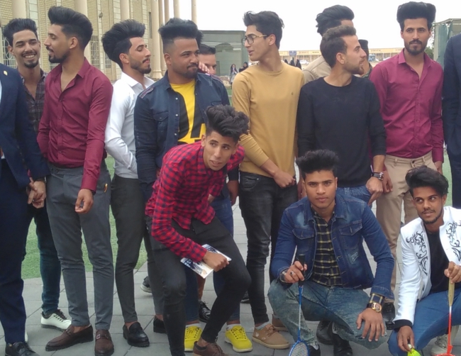 Een groep studenten met typische kapsels uit Bagdad maakt zich klaar voor de foto. Foto: Sylva van Rosse