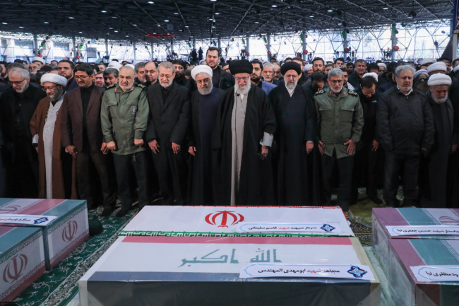 Begrafenis van Qasem Soleimani, op 6 januari 2020 in Teheran. In het midden de Iraanse geestelijk leider Khamenei, naast hem, met de witte tulband, president Rohani ©Foto khamenei ir./Wikimedia commons 